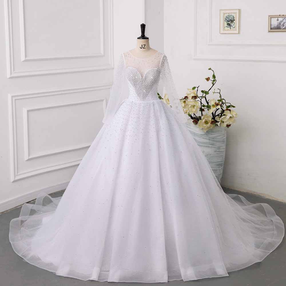 Elegant sweetheart tulle wedding dress featuring long sleeves and intricate bead detailing