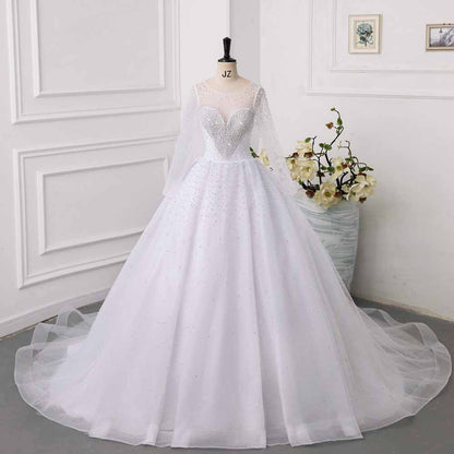 Elegant sweetheart tulle wedding dress featuring long sleeves and intricate bead detailing