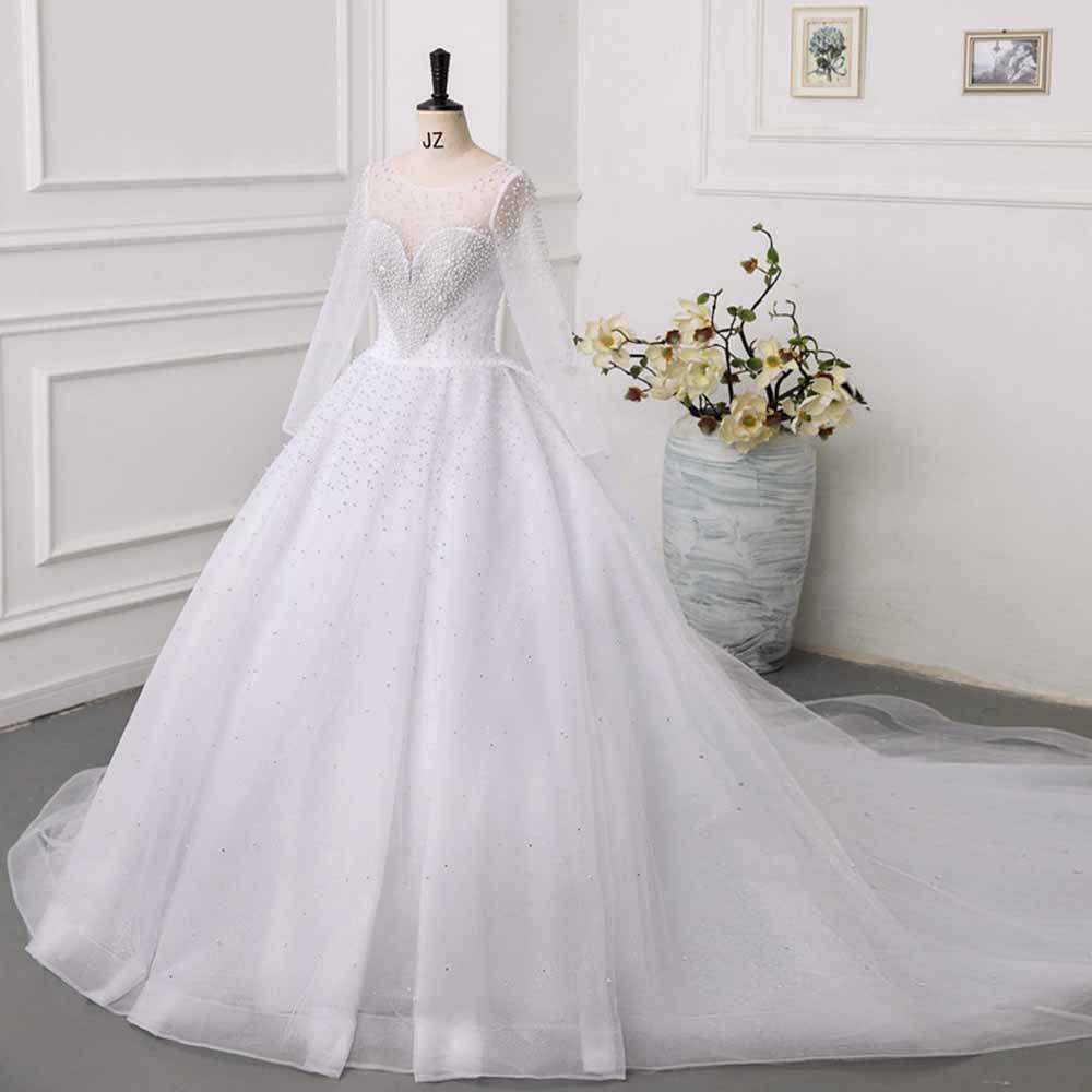 Elegant sweetheart tulle wedding dress with long sleeves and beaded details for a stunning bridal look