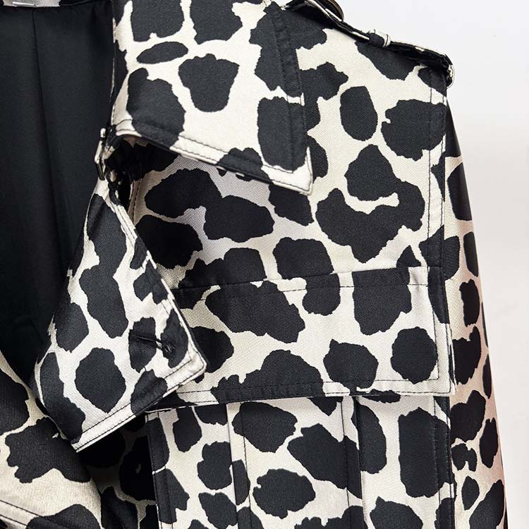 Close-up of a tailored animal print long coat featuring a black and white spotted pattern