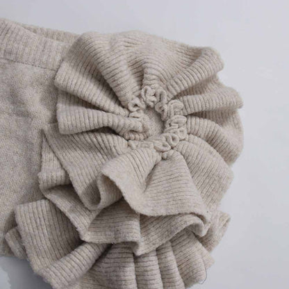Textured detail of a beige three piece women's sweater set featuring ruffled sleeves for a stylish look