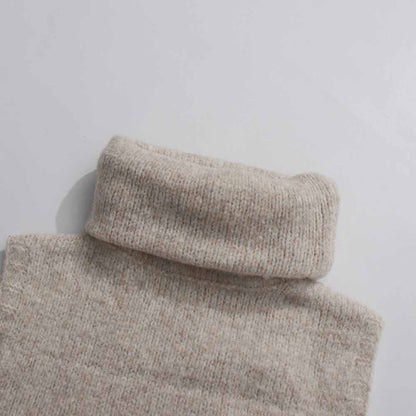 Close-up of a cozy beige turtleneck from a three piece women's sweater set for stylish layering