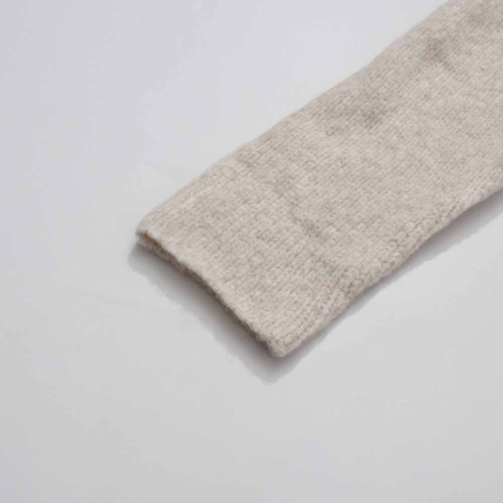 Close-up of a sleeve from a three piece women's sweater set in soft beige knit fabric