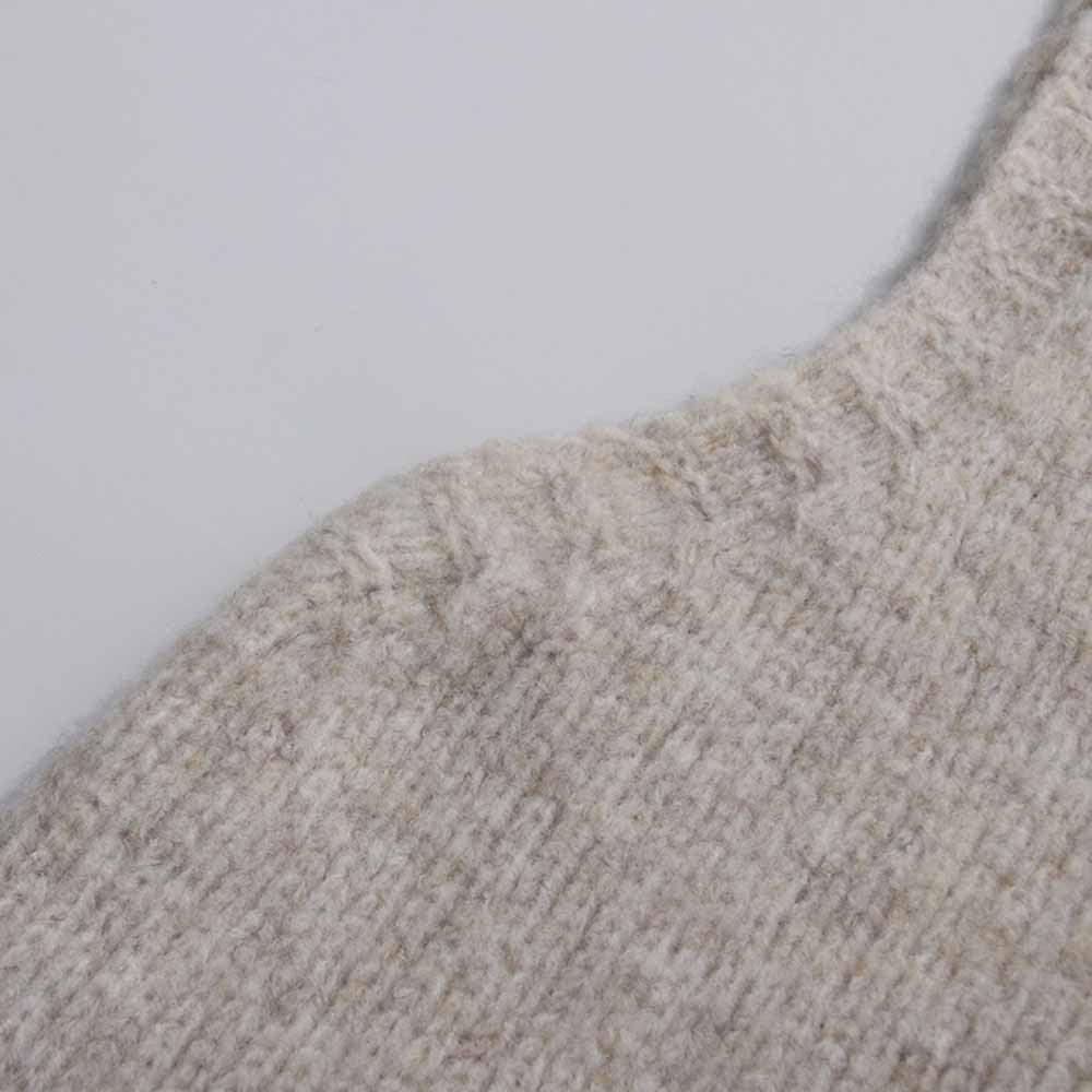 Detail of a soft beige fabric from a three piece women's sweater set for comfortable layering