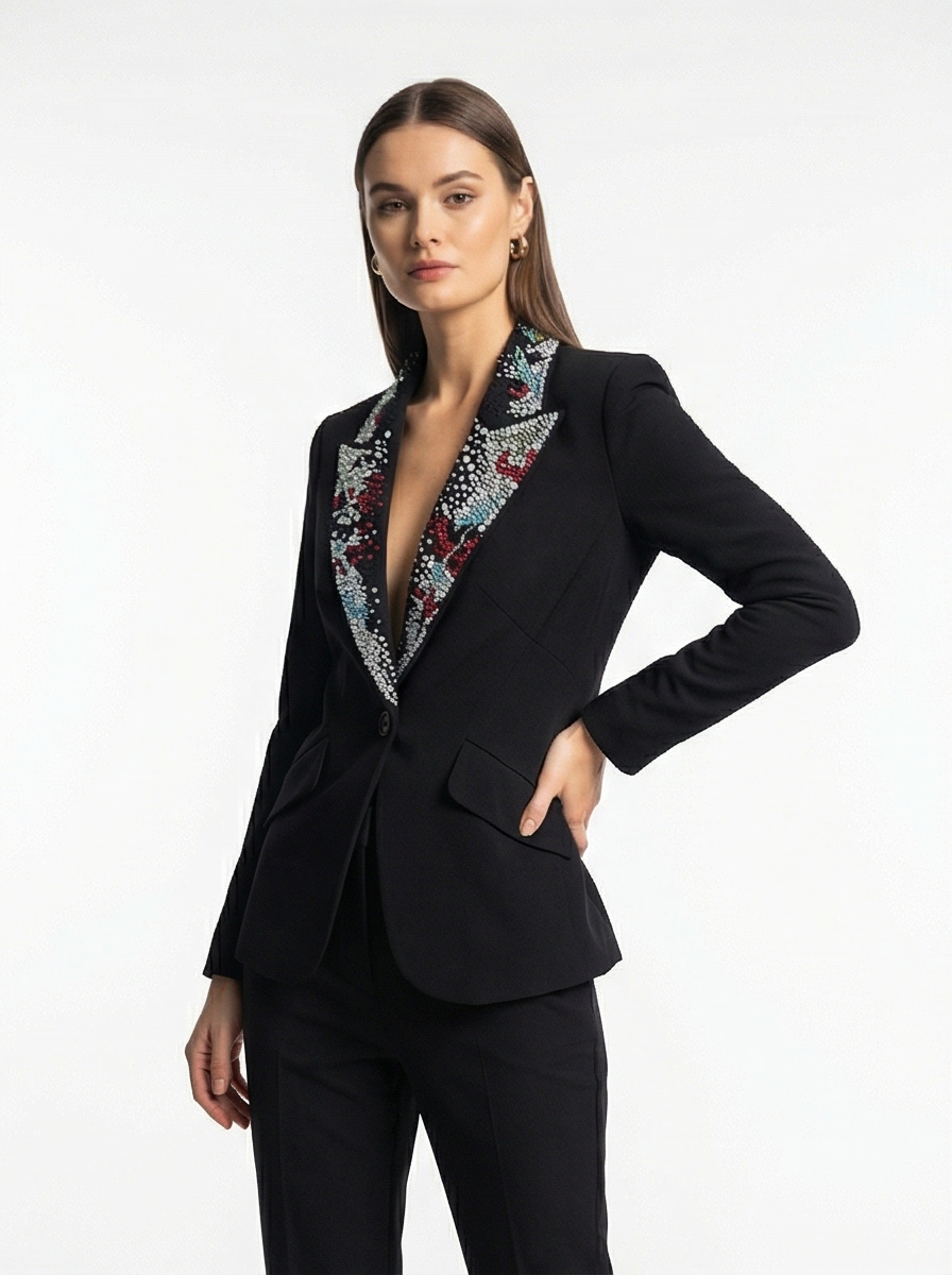 Woman wearing a black suit with a patterned collar on a white background