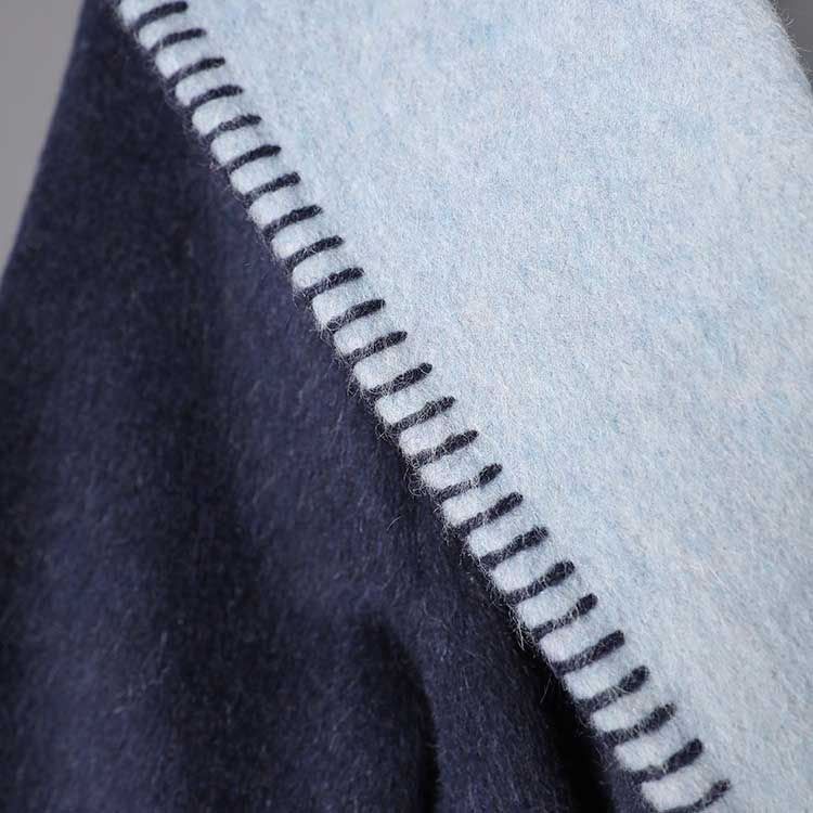 Close-up of the fabric texture showcasing a two-sided winter coat women in navy and light blue shades