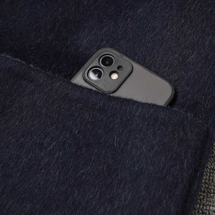 Close-up of a pocket in a two-sided winter coat women with a smartphone inside for convenience