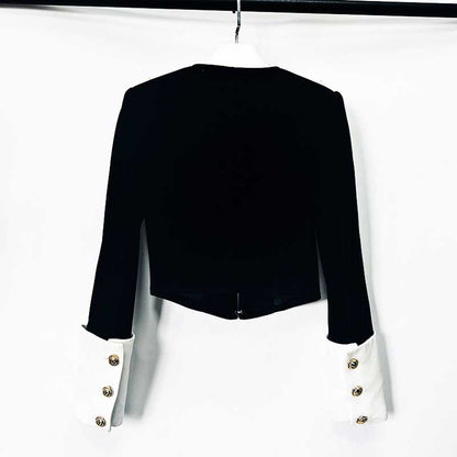 Elegant velvet black blazer with contrasting white cuffs and gold buttons for a chic look