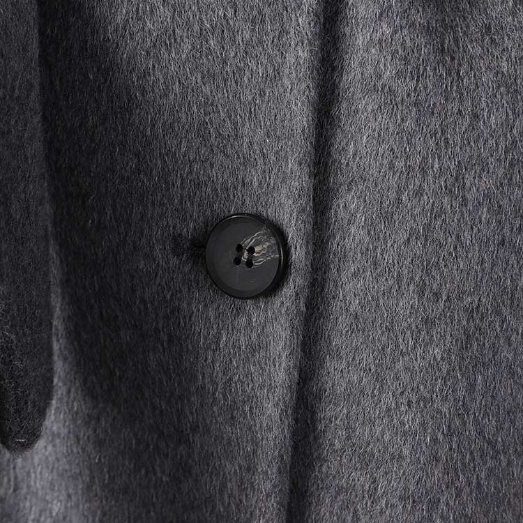 Close-up of a women's double-breasted grey coat featuring a stylish button detail