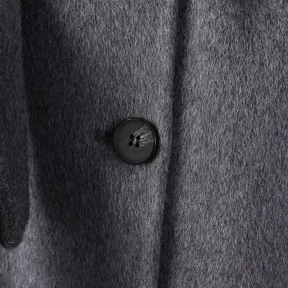 Close-up of a women's double-breasted grey coat featuring a stylish button detail