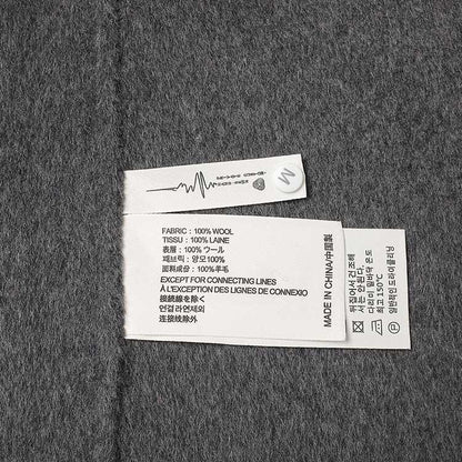 Label of women's double-breasted grey coat showing fabric details and care instructions