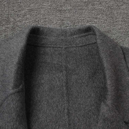 Close-up of the collar on a women's double-breasted grey coat highlighting soft fabric and stitching details