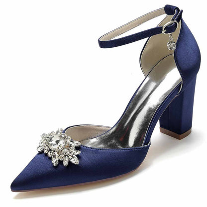Elegant point toe satin wedding shoes in navy blue with a jeweled embellishment and ankle strap