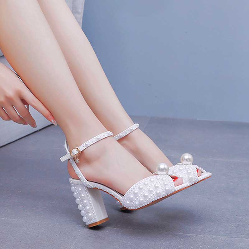 White chunky wedding sandals featuring pearl embellishments and ankle straps
