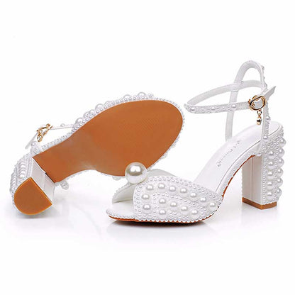 White chunky wedding sandals with pearl embellishments and sturdy block heels for a stylish bridal look