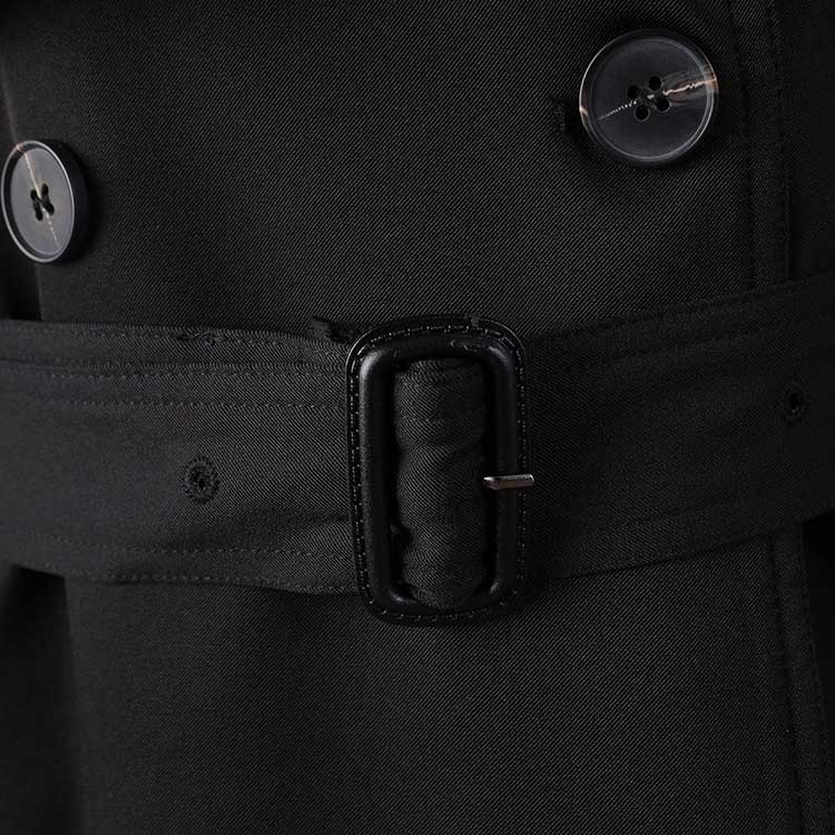 Close-up of a black British style trench coat for women featuring buttons and a waist belt