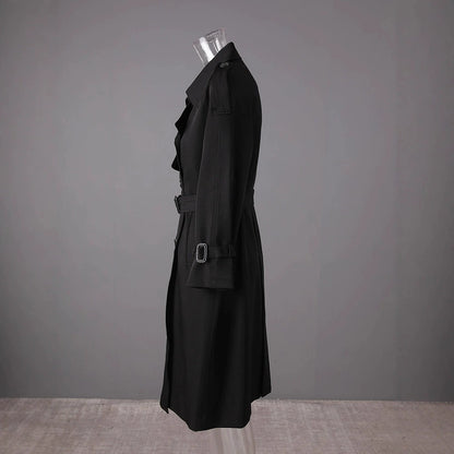 Side view of a black British style trench coat for women with a belted waist and classic silhouette