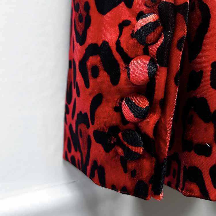 Close-up of a slim fit animal print suit for women featuring a vibrant red pattern and stylish buttons