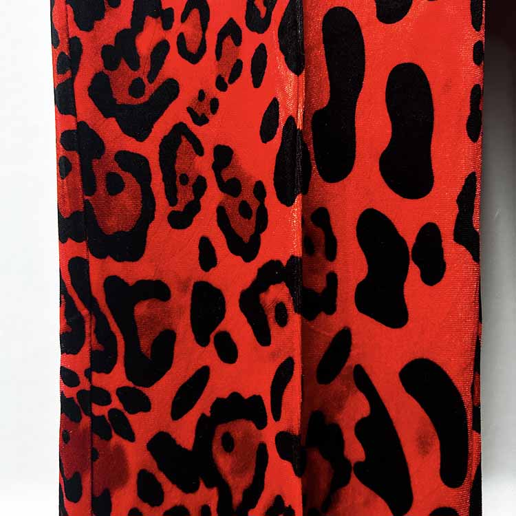 Close-up of a slim fit animal print suit for women featuring bold red and black designs