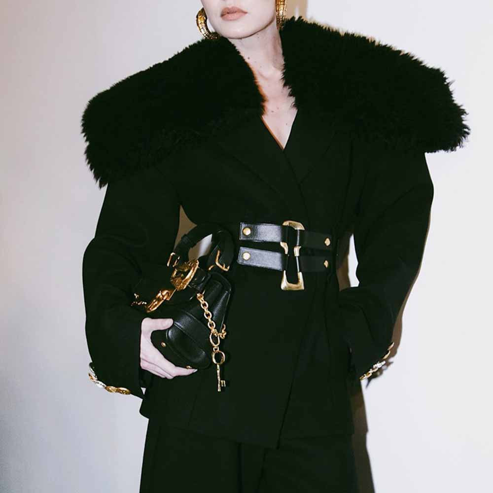 Stylish women's black belted winter coat with faux fur collar and statement belt for a fashionable look