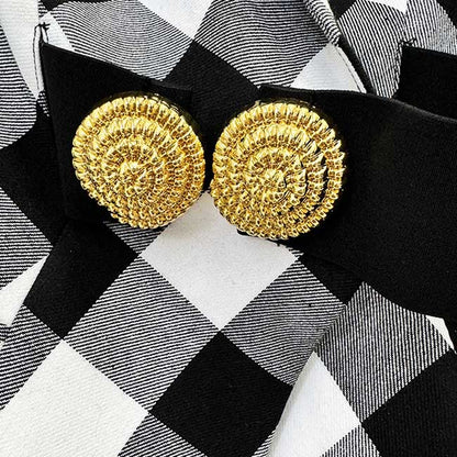 Close-up of women's black checked blazer coat featuring ornate gold buttons for stylish detailing