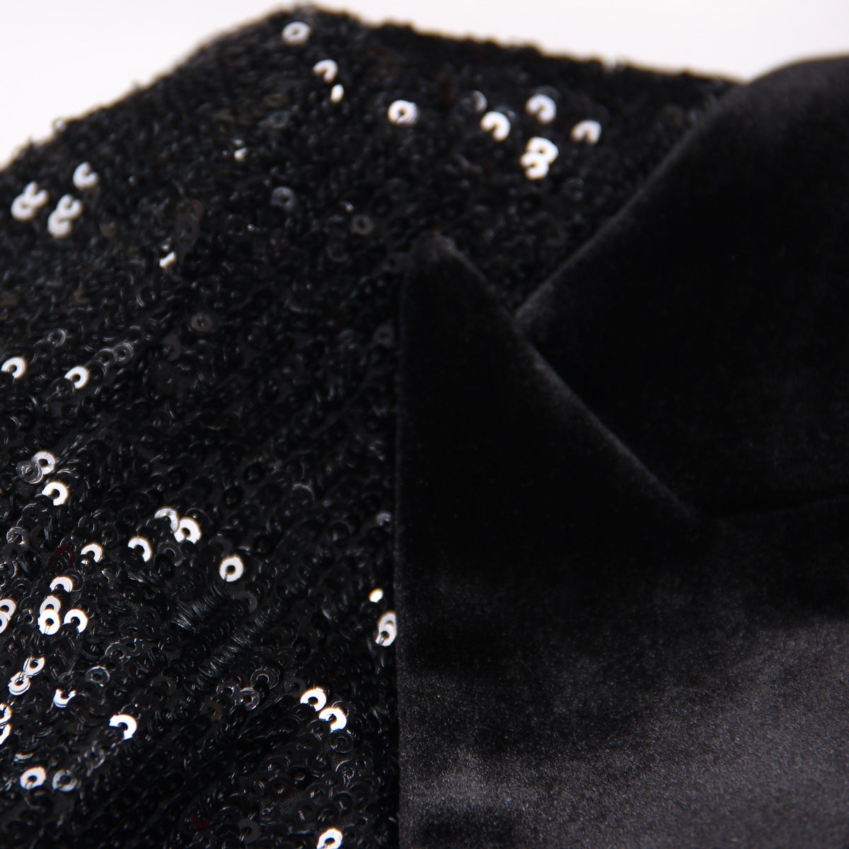 Close-up of women's black sequin blazer showcasing intricate sequins and elegant shawl collar