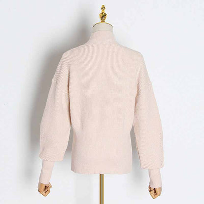 Back view of a women's bow detail sweater in soft pink with relaxed sleeves and ribbed texture