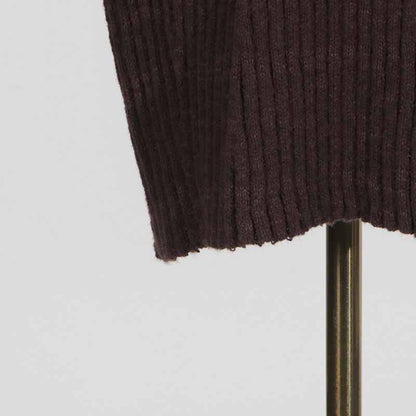 Close-up of a women's cozy knit mini dress showing ribbed texture and warm fabric details