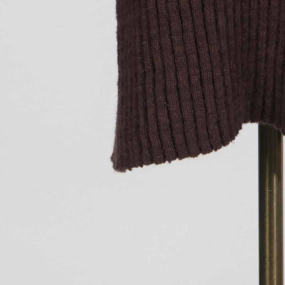 Close-up of a women's cozy knit mini dress featuring ribbed texture and hem detail