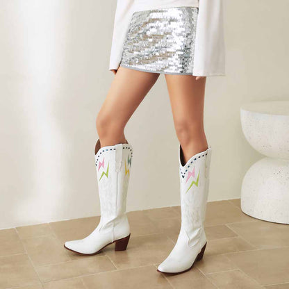 Stylish women's embroidered cowboy boots in white with colorful designs, perfect for trendy outfits.