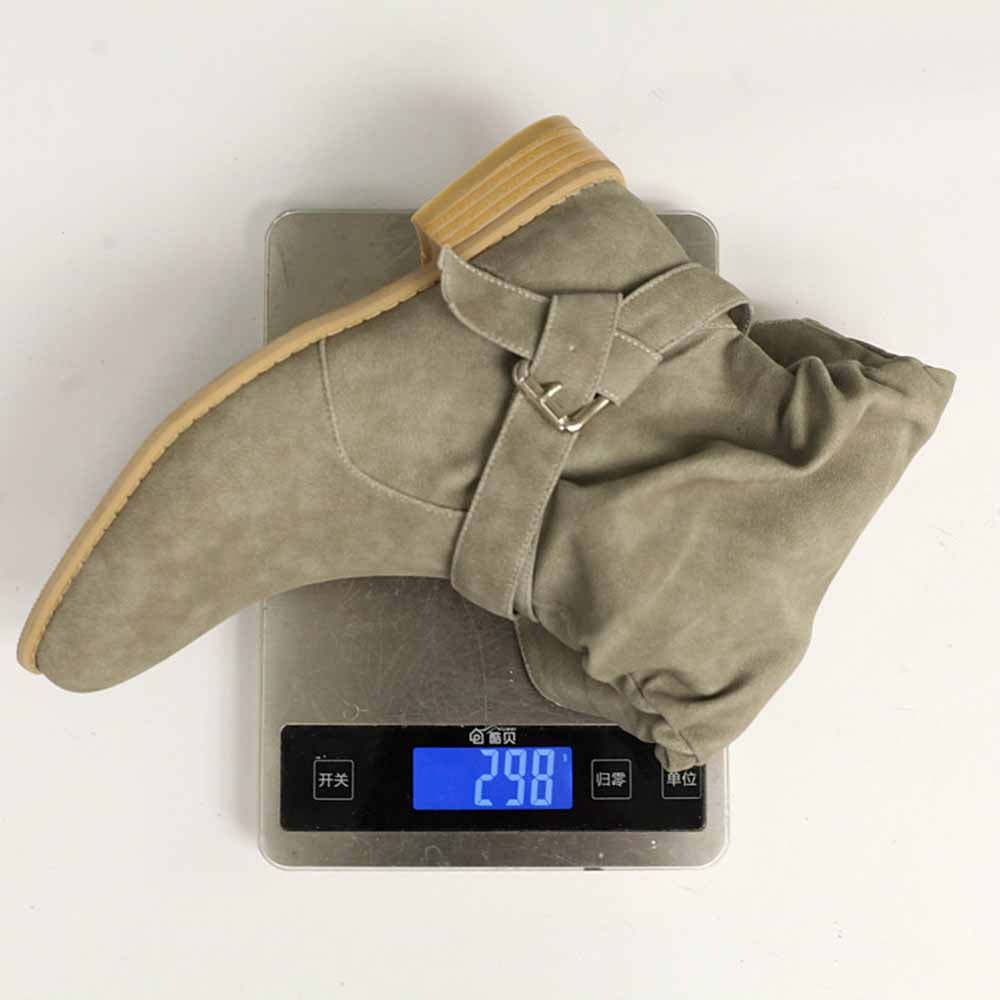 Women's flat suede ankle boots in gray displayed on a digital scale showing weight