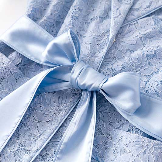 Elegant women's formal lace pantsuit for wedding in soft blue with a satin bow detail