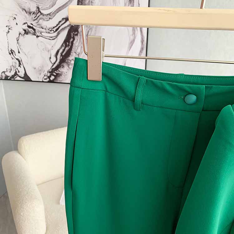 Close-up of women's green pantsuit formal featuring a tailored waistband and sleek design