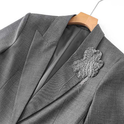 Close-up of women's grey tailored pantsuit featuring a stylish design and intricate embellishment