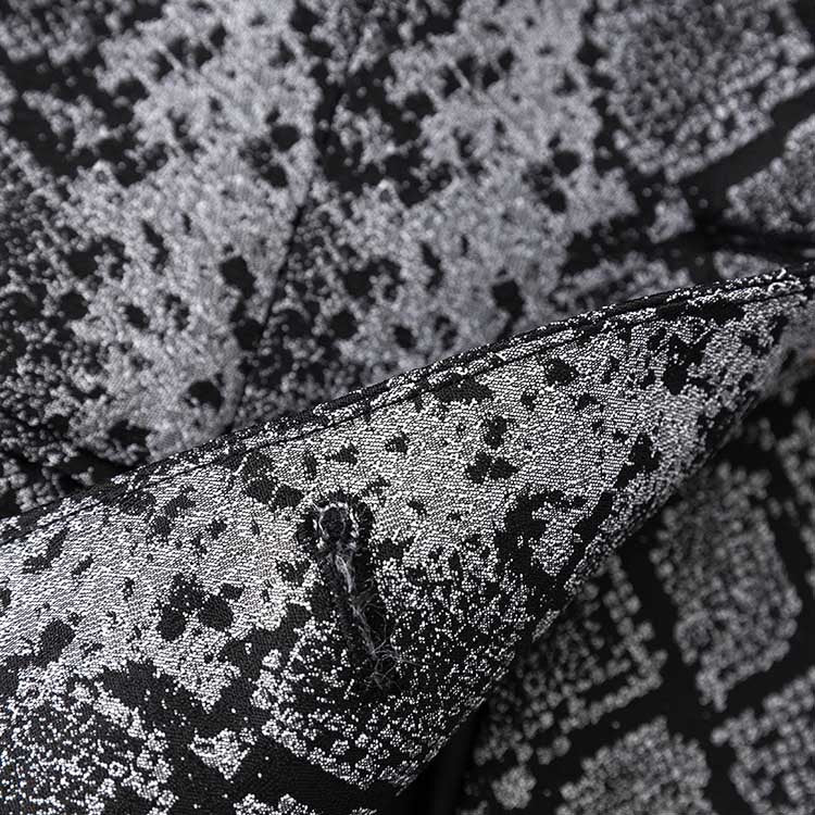 Close-up of women's jacquard blazer black showcasing intricate fabric texture and design