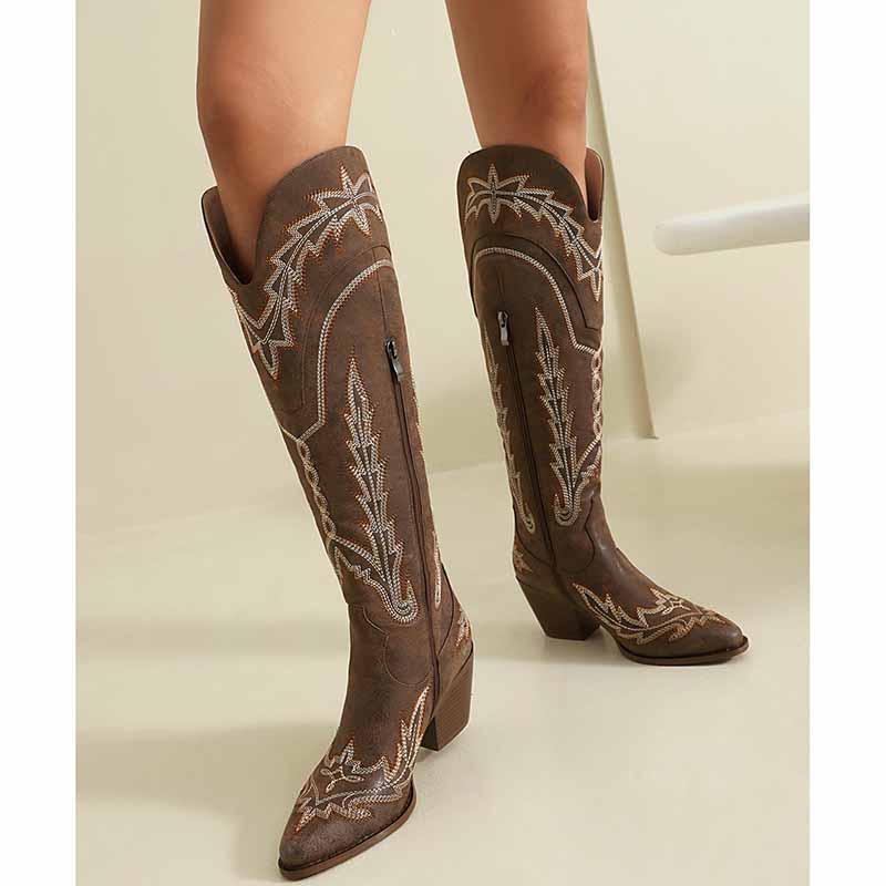 Brown women's knee high cowboy boots with intricate stitching and stylish zip detail