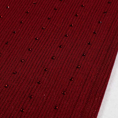Close-up of a luxurious burgundy fabric with shimmering details, ideal for a women's knitted crop top and midi dress set