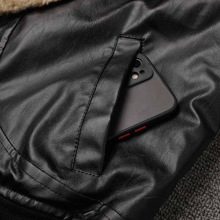 Close-up of a women's leather effect jacket with shearling collar featuring a phone in the pocket