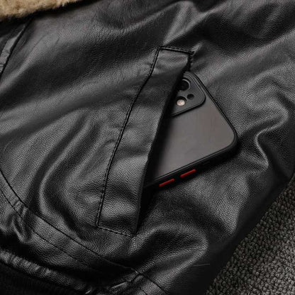 Close-up of a women's leather effect jacket with shearling collar featuring a phone in the pocket
