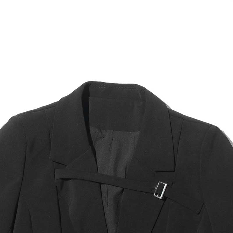 Close-up of a women's maxi blazer coat featuring a unique buckle design in black fabric