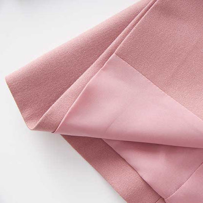 Close-up of women's pink pantsuit fabric showcasing soft texture, ideal for formal events