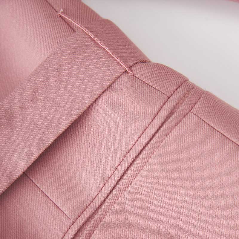 Close-up of a women's pink pantsuit for formal events, featuring tailored seams and elegant fabric texture