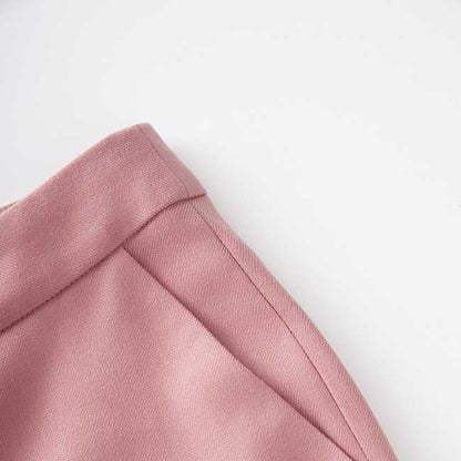 Close-up of women's pink pantsuit for formal events with tailored seams and soft fabric texture