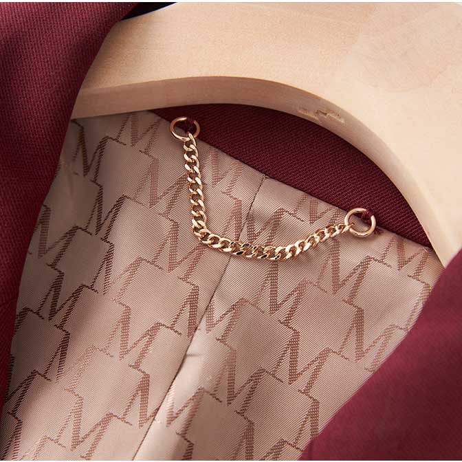 Close-up of women's straight-leg pants suit detailing with chain hanger in rich maroon color