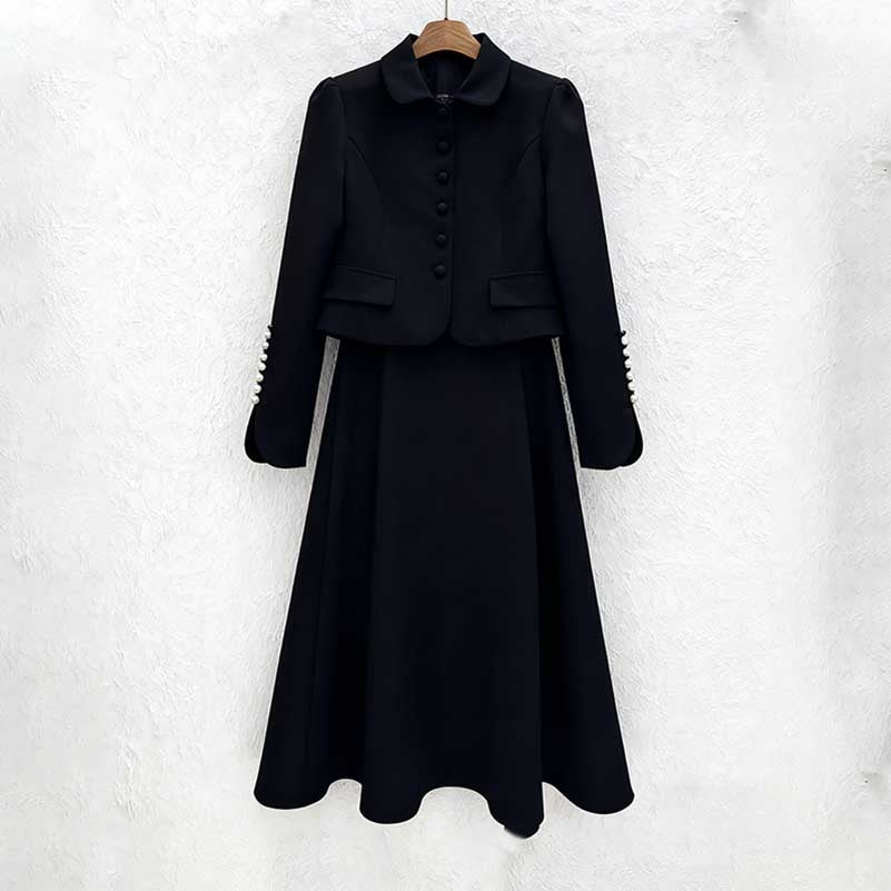 Elegant women's two piece skirt suit in black with a tailored jacket and flowing skirt