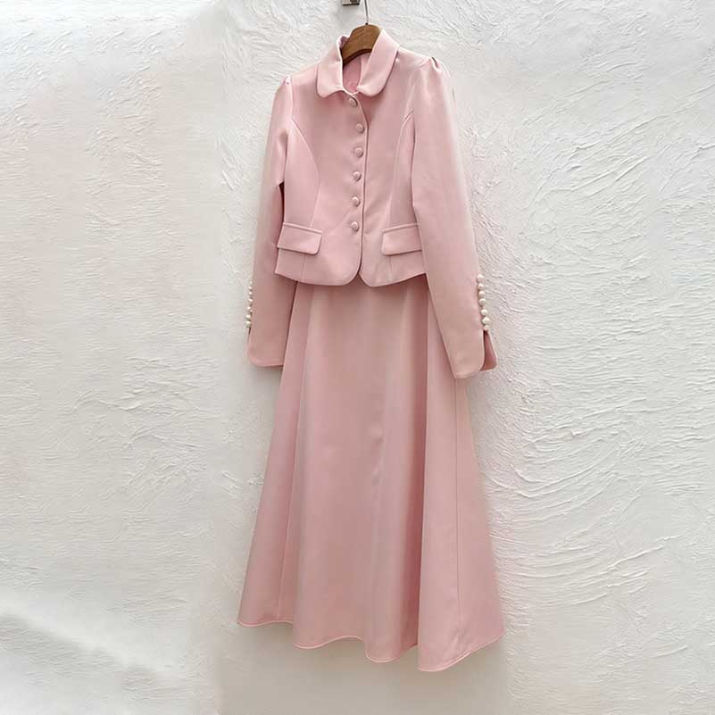 Pink women's two piece skirt suit featuring a stylish jacket and flowing skirt for elegant occasions