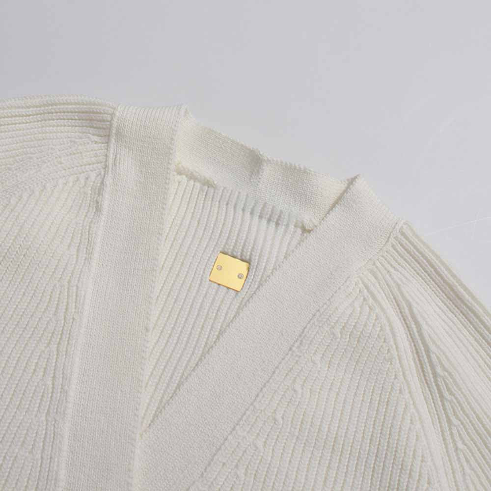 Women's v neck knitted cardigan in cream color featuring ribbed texture and stylish gold logo detail
