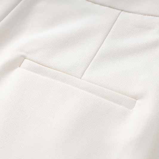 Close-up of women's white pantsuit set showing sleek fabric and elegant pocket detail