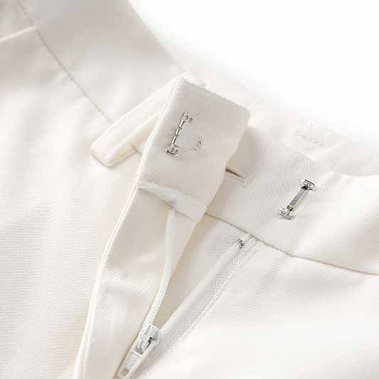 Close-up of the zipper and fastening details on a women's white pantsuit set by sd-hk
