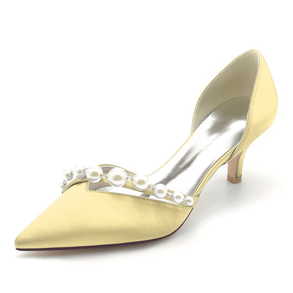 yellow- high-heeled shoe with pearl embellishments on a white background